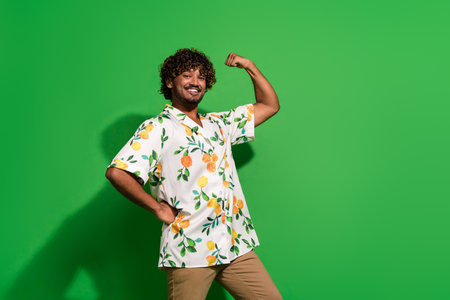 Photo portrait of attractive young man show muscles fist dressed stylish citrus print clothes...