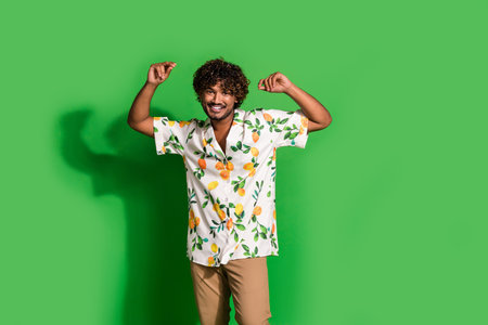 Photo of positive cheerful latin guy dressed print shirt dancing having fun isolated green color...
