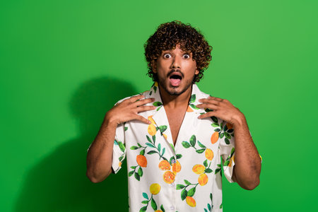 Photo of impressed funky arabian man wear print shirt open mouth empty space isolated green color backgroundの写真素材