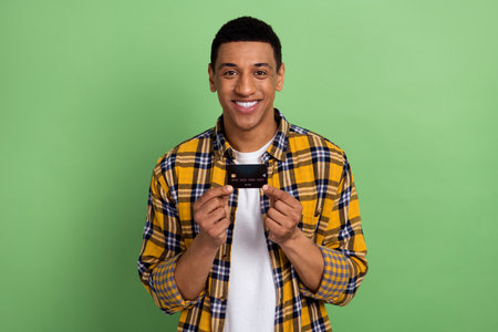 Portrait of young guy in shirt demonstrate vip client credit card wireless payment service and sales...