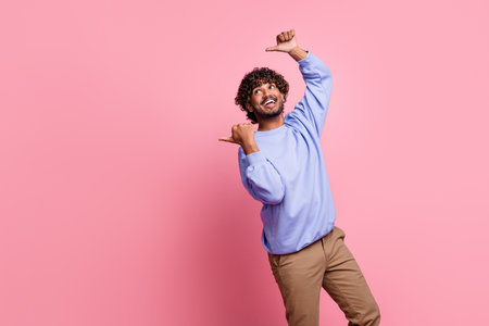 Photo portrait of attractive young man point interested banner empty space wear trendy blue clothes isolated on pink color backgroundの写真素材