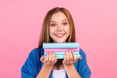 Photo of cheerful positive girl wear blue shirt enjoying learning book isolated pink color backgroundの写真素材