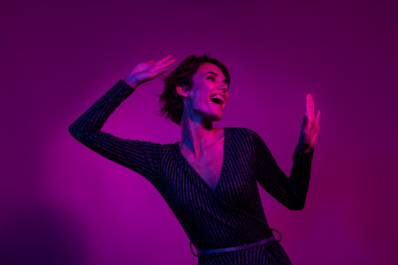 Photo portrait of attractive young woman raise hands dancing wear trendy overall clothes isolated on neon light pink color backgroundの写真素材