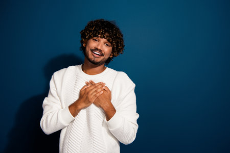 Photo of young sincere boyfriend saying his true love touching chest handsome cute mexican guy isolated on dark blue color backgroundの写真素材