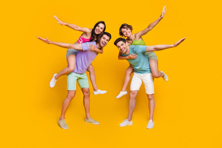 Full size photo of girls feel playful flying plane on piggyback guys isolated bright color backgroundの写真素材