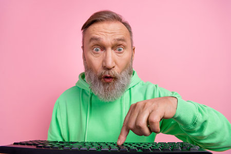 Photo portrait of handsome senior man amazed press key texting keyboard dressed stylish green...
