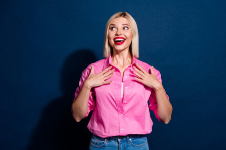 Portrait of overjoyed girl with bob hairdo wear stylish shirt look at impressive sale empty space isolated on dark blue backgroundの写真素材