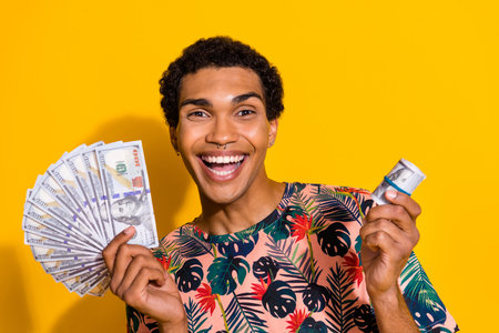 Photo of young funny successful business man holding his cryptocurrency withdraw into real banknotes...
