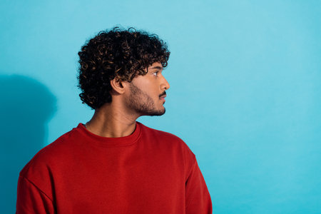 Profile portrait of focused concentrated young man calm face look empty space isolated on blue color backgroundの写真素材