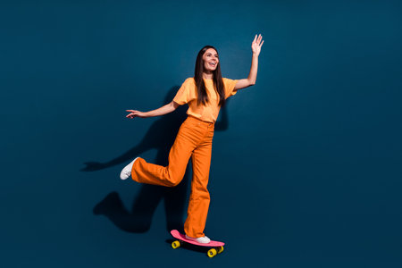 Full body size photo of young active and sportive lady ride penny board looking far away down street...