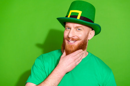 Portrait of funky minded smart man arm touch beard chin brainstorming isolated on green color...