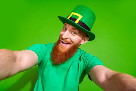 Portrait of cheerful charismatic man have good mood take selfie record video isolated on green color backgroundの写真素材