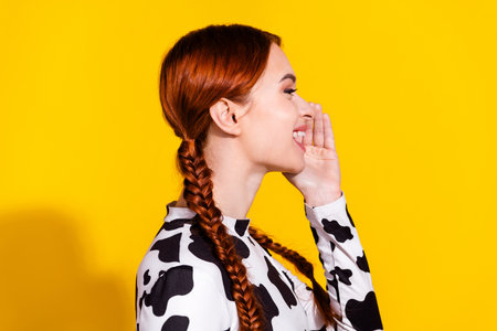 Photo of adorable excited woman wear cow skin top shouting announcement empty space isolated yellow color backgroundの写真素材