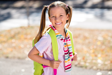 Photo of funny pretty little girl dressed tied sweater rucksack finishing lessons walking home...