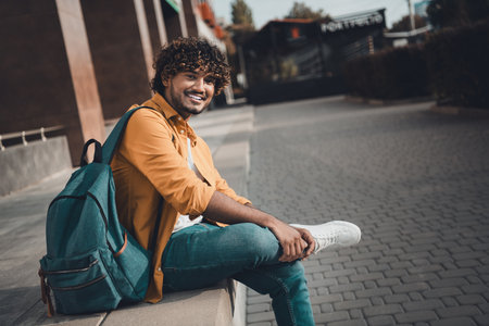 Photo of glad cheerful man exchange student studying international college sunny spring days...