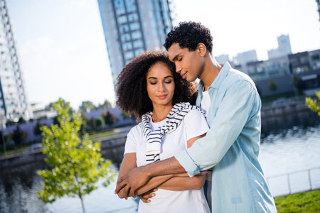 Portrait of sweet pretty couple beautiful young charming wife enjoy lovely cuddles with husband at kyiv city on background outdoorsの写真素材