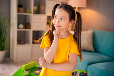 Photo portrait of cute small girl touch chin look thoughtful empty space dressed stylish yellow...