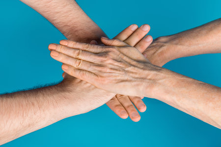 Photo of two mature young people arms palms hands practicing team building exercises isolated blue...