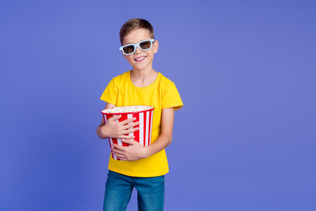 Photo of cute cheerful small boy wear trendy yellow clothes enjoy weekend 3d cinema isolated on purple color backgroundの写真素材