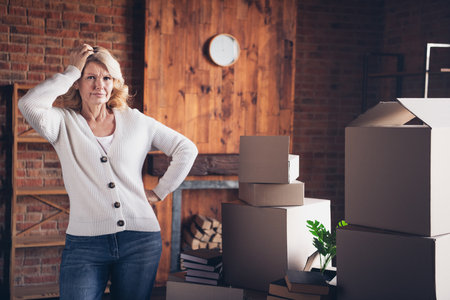 Photo portrait of lovely retired woman confused stack carton boxes wear casual clothes cozy home...