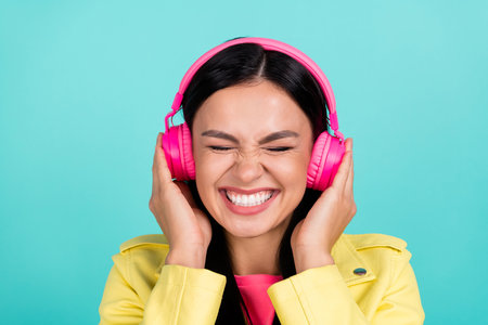 Photo of young excited girl listen radio pop music headphones isolated over turquoise color backgroundの写真素材