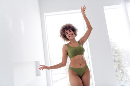 Photo portrait of pretty lovely young girl raise arms have fun no retouch wear khaki lingerie isolated on white day light studio backgroundの写真素材