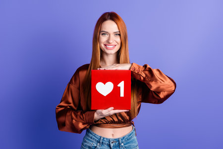 Portrait of nice young woman hands hold like notification icon wear brown shirt isolated on purple...