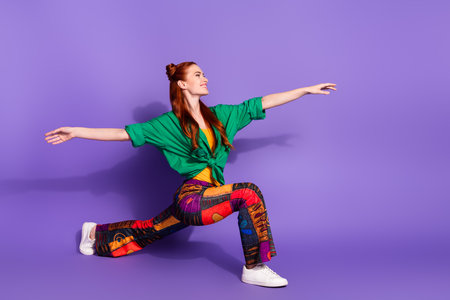 Full length photo good mood girl wear trousers vintage shirt stretching look at promo empty space isolated on violet color backgroundの写真素材