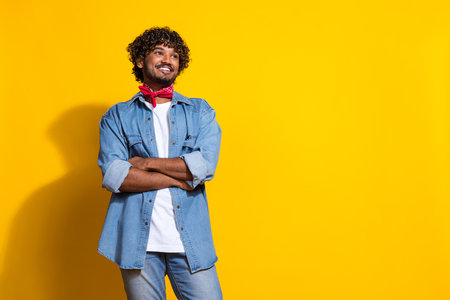 Photo portrait of nice young male folded hands look empty space wear trendy denim outfit red scarf isolated on yellow color backgroundの写真素材