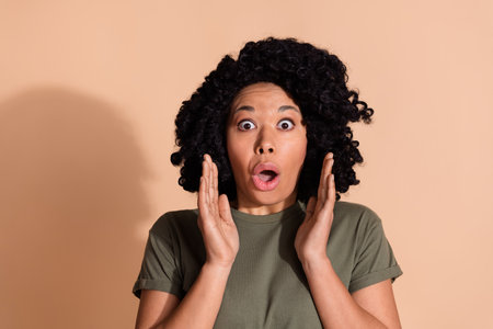 Photo portrait of pretty young woman frightened raise hands dressed trendy khaki outfit isolated on...
