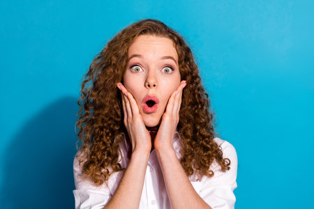 Photo of lovely cute nice girl wear stylish white clothes arms touch face wow sale news isolated on blue color backgroundの写真素材