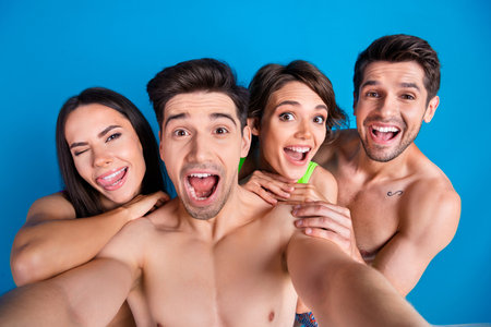 Photo of flirty tricky fellows company wear swimsuits vlogging recording video stick out isolated...