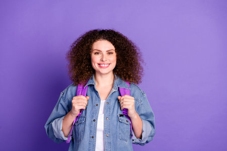 Portrait of pretty young woman rucksack empty space wear denim shirt isolated on purple color...