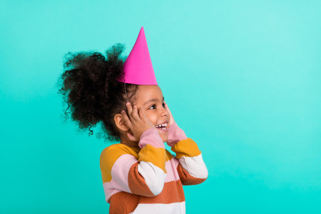 Photo of cheerful crazy little lady look up empty space hands cheeks wear striped pullover isolated...
