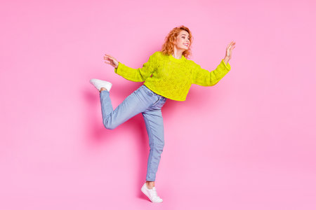 Full length photo of nice cheerful lovely girl dressed stylish green outfit empty space isolated on bright pink color backgroundの写真素材