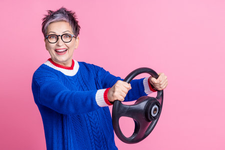 Photo of pretty cheerful positive woman wear blue clothes hold steering wheel empty space isolated...