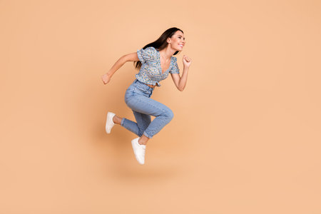 Photo of glamour lovely funny woman wear blue clothes look run empty space isolated on beige color...