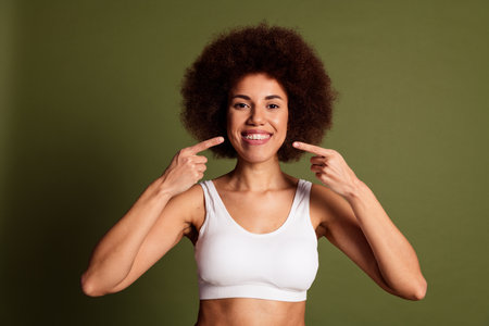 No filter photo of cheerful lady underwear lingerie loving body positive pointing braces isolated khaki color backgroundの写真素材