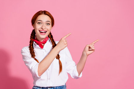 Photo of cheerful pretty girl wear white trendy clothes introduces empty space special sale price offer isolated on pink color backgroundの写真素材