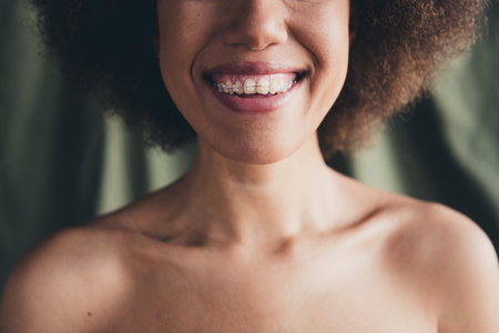 Photo portrait of lovely young lady toothy smile braces shoulders off green studio background no filter self acceptance all body perfectの写真素材