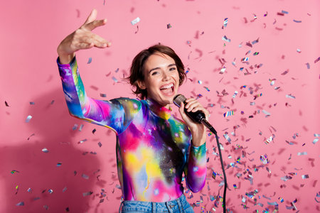 Photo of nice young woman enjoy sing microphone wear pullover isolated on pink color backgroundの写真素材