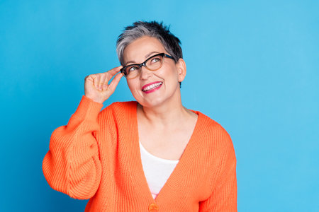 Photo portrait of lovely senior lady touch specs look empty space dressed stylish orange garment...