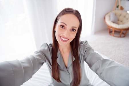 Photo of cute charming lady wear grey pajama enjoy weekend tacking selfie indoors house bedroom