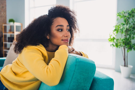 Photo of pretty shiny lady dressed yellow sweatshirt smiling having rest sofa indoors house roomの写真素材