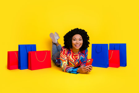 Full body portrait of nice young woman phone mall bags wear pullover isolated on yellow color...