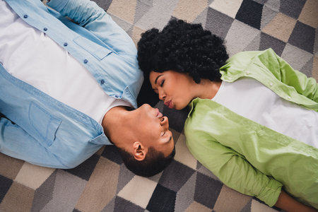Top view photo of sweet adorable couple dressed casual outfit blowing kisses lying floor indoors house roomの写真素材