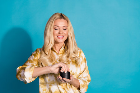 Photo portrait of stunning mature lady hold open cream jar dressed stylish formalwear clothes isolated on cyan color backgroundの写真素材