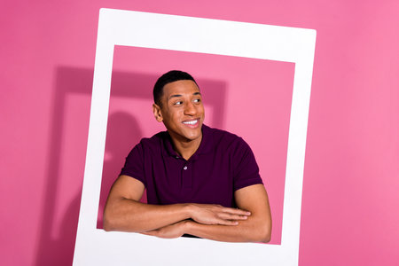 Photo portrait of nice young male look empty space instant photo frame dressed stylish violet garment isolated on pink color backgroundの写真素材