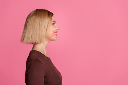 Photo of lovely adorable nice girl wear stylish brown clothes look empty space isolated on pink color backgroundの写真素材