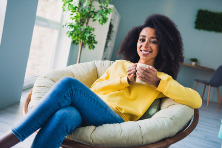 Photo of charming lovely pretty girl drinking tasty tea enjoying relax rest in cozy apartment indoorsの写真素材